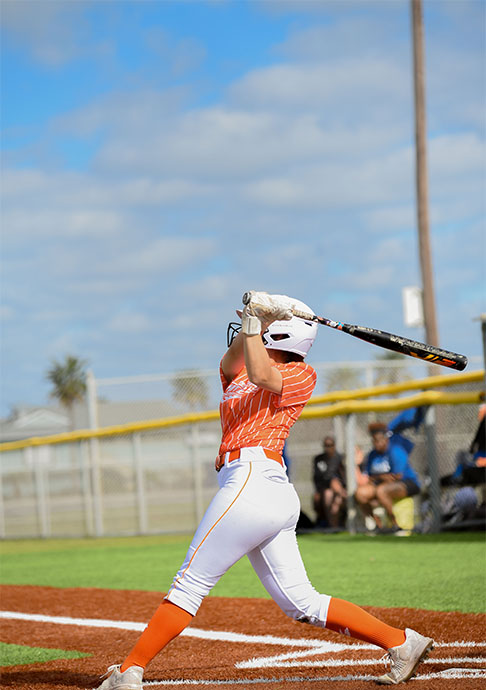 Softball player swings at the plate