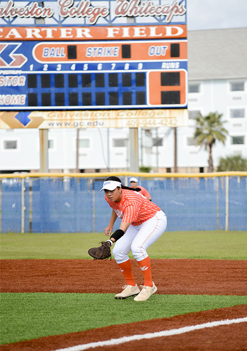 Softball player gets ready to catch a ball near first base