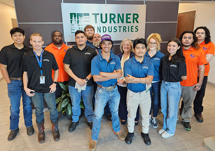 Members of the Galveston College welding program stand in front of the Turner Industries lobby.