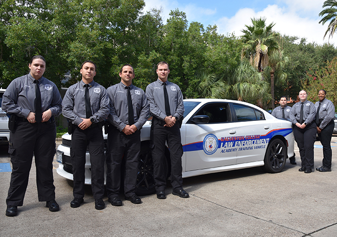 7 students from Galveston College Law Enforcement Academy stand by new training car.