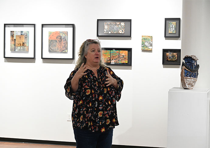 Person in art gallery with illustrations and scuptures