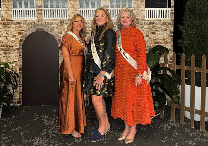 Three people women with sashes stand together