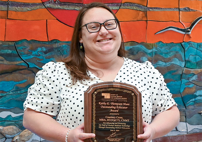 Educator stands with award