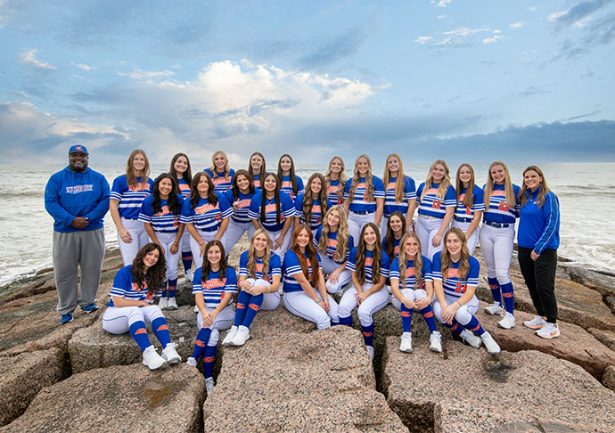 The 2025 Galveston College Whitecaps softball team poses on the beach at Galveston Island.