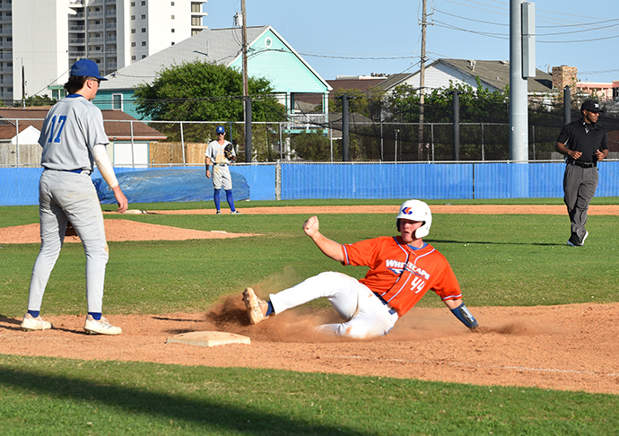 Baseball player slides into base.