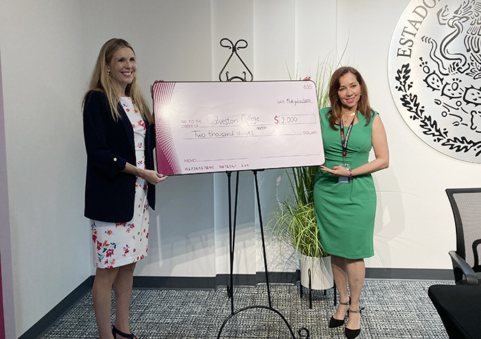 Two women stand with scholarship check.