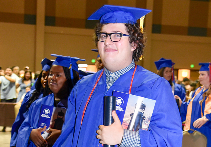 Tate Burchfield, high school student, poses in his cap and gown.