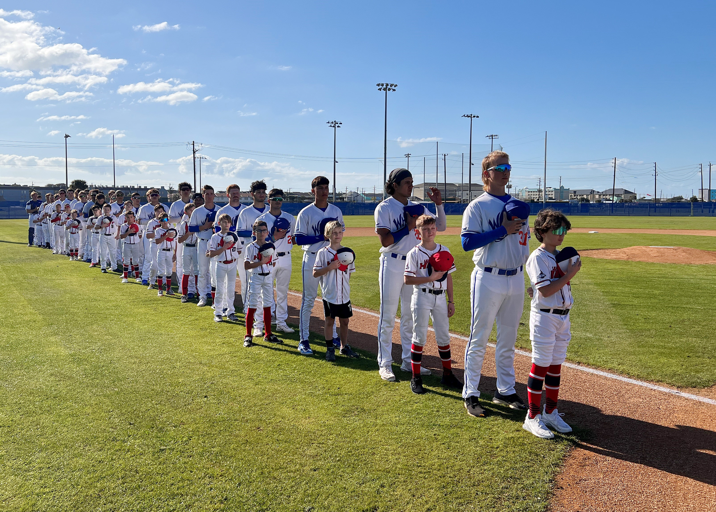 Galveston College players lineup for the national anthem with the League City Heat youth team prior to the start of the Whitecaps home opener on Sunday, Feb. 5, 2023 at Bernard Davis Stadium in Galveston.
